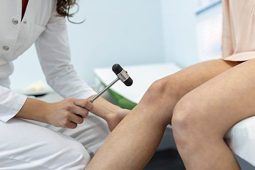 A woman is getting her knee examined by a doctor.