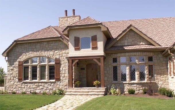 A large stone house with a shingle roof