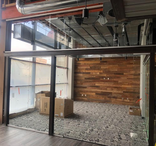 An empty room with a wooden wall and boxes on the floor