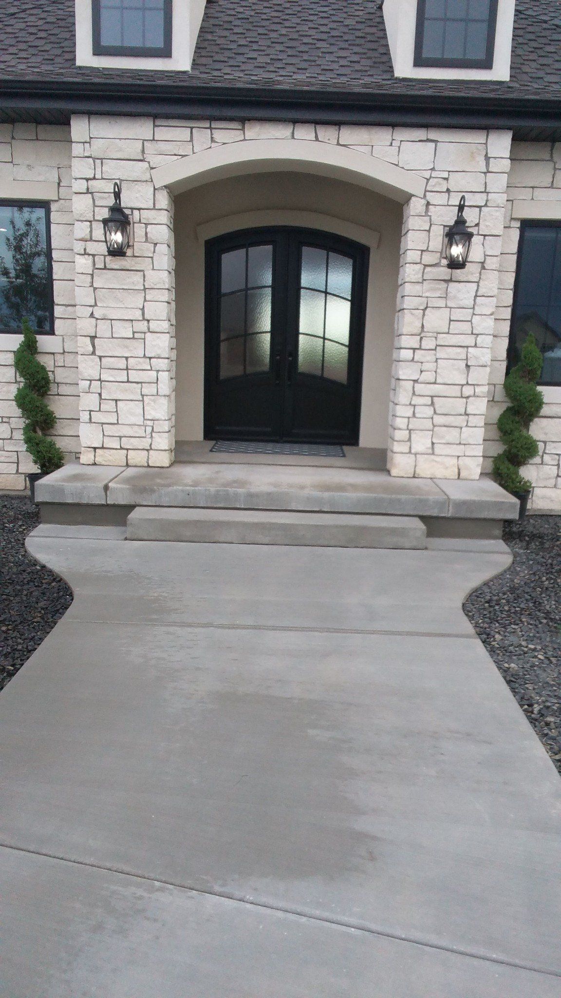 There is a concrete walkway leading to the front door of a house.