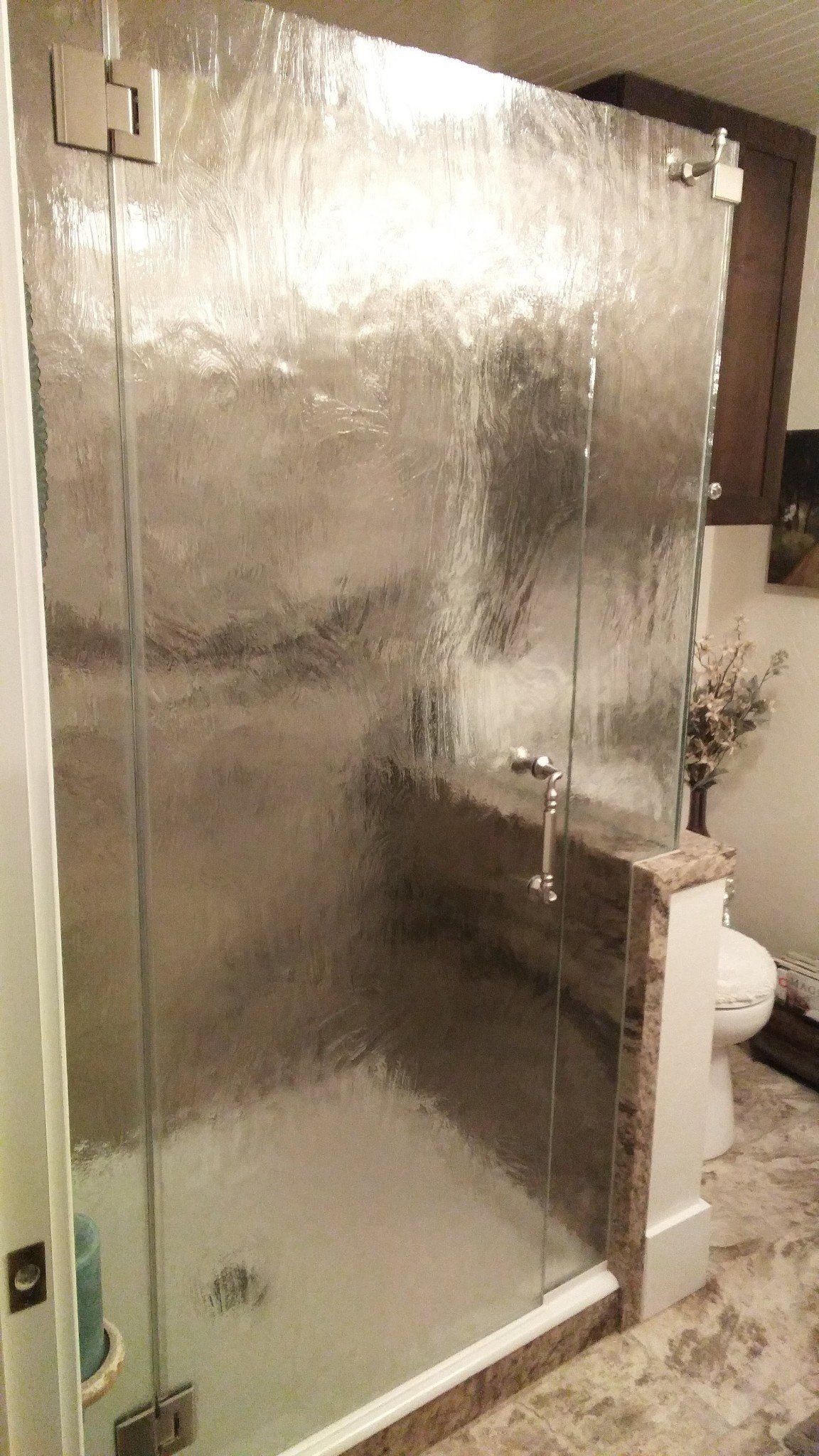 A bathroom with a walk in shower and a toilet.