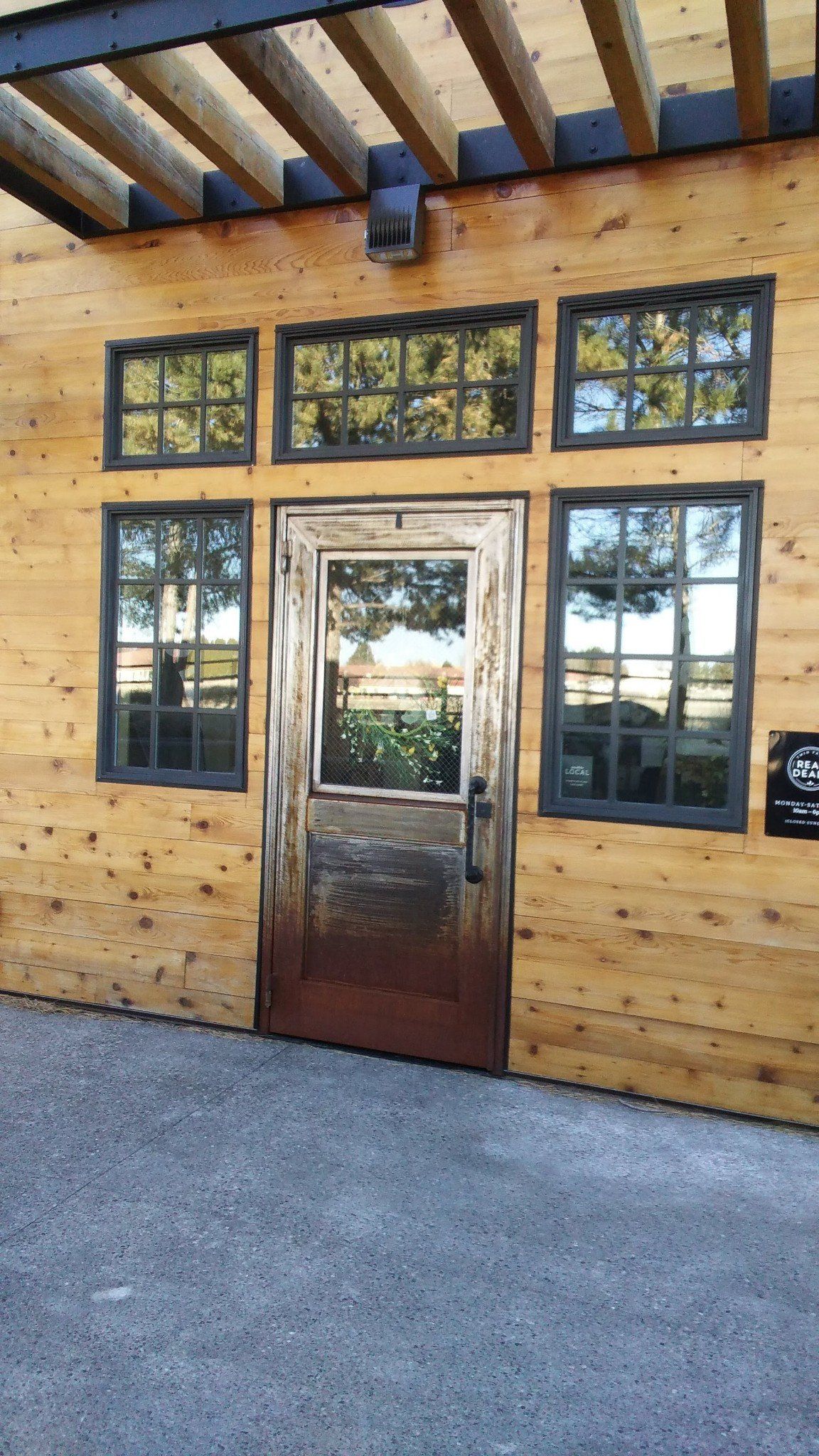 A wooden building with a metal door and windows.