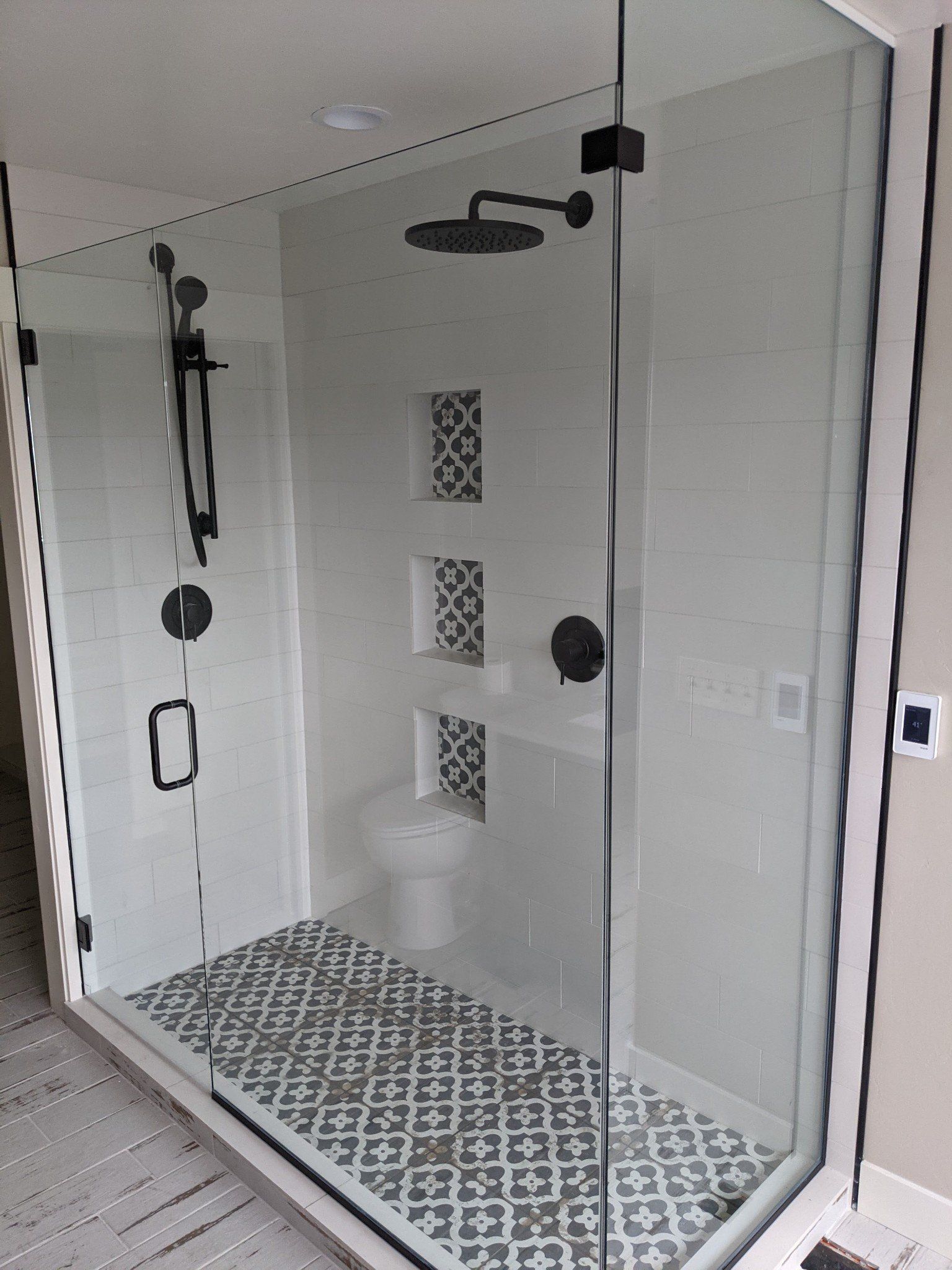 A bathroom with a walk in shower and a toilet.