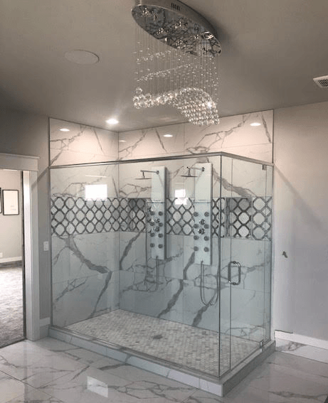 A bathroom with a walk in shower and a chandelier hanging from the ceiling.
