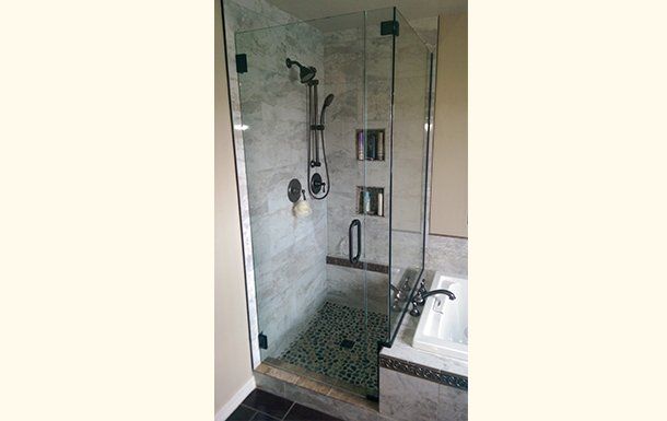 A bathroom with a walk in shower and a sink.