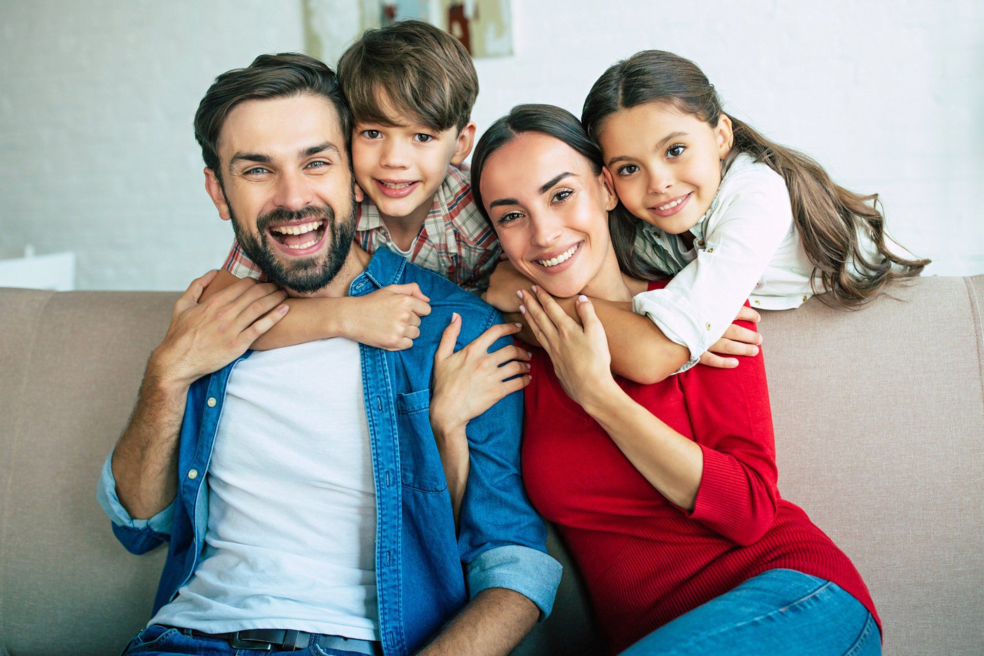 Family Relaxing And Children Hugging Their Parents At Home