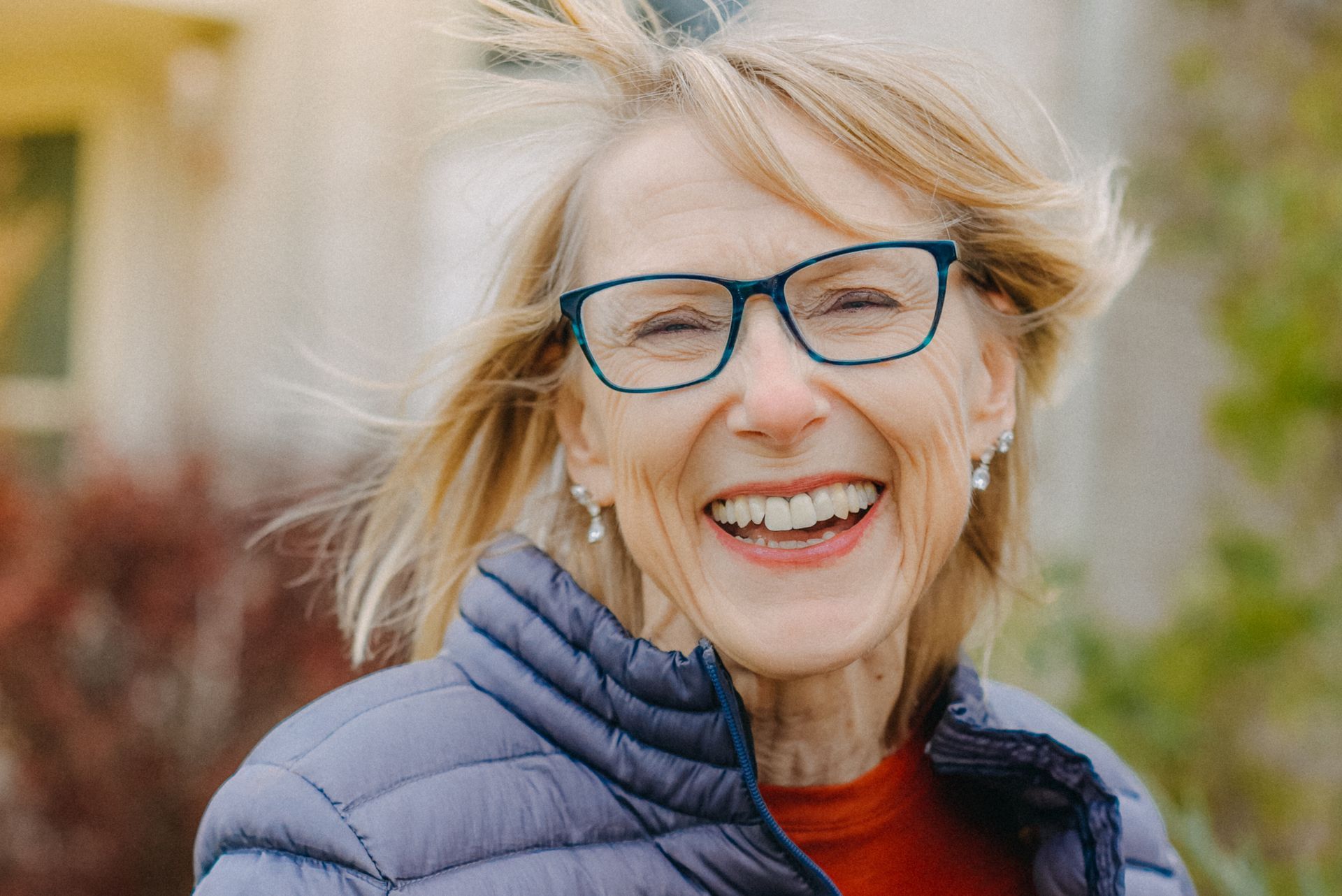Woman in specs and jacket is smiling