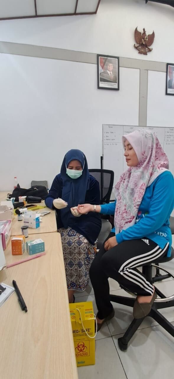A group of women in hijabs take notes in a brightly lit room.
