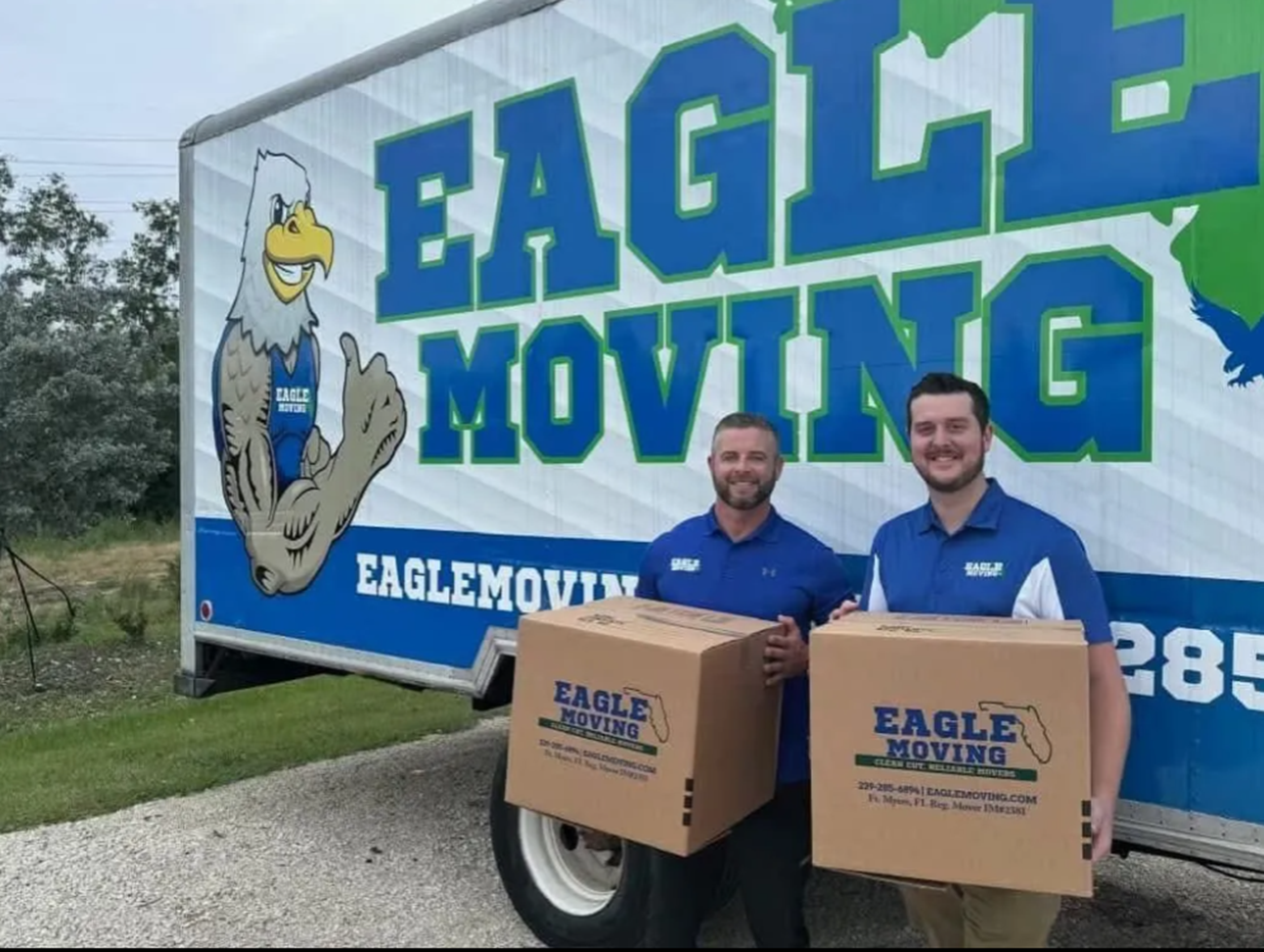 Professional staff holding boxes in front of a truck for a reliable local mover company.