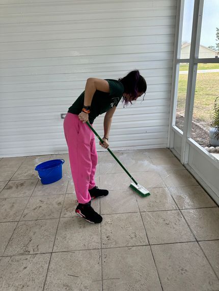 A woman is cleaning the floor with a mop.