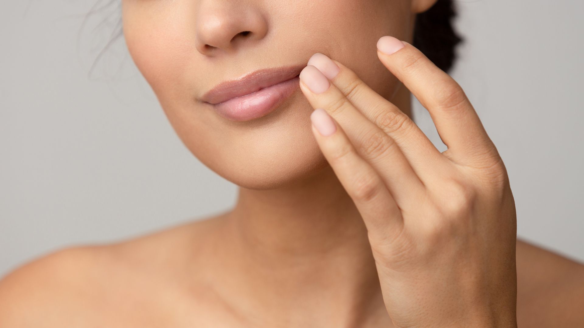 A close up of a woman 's face with her hand on it.