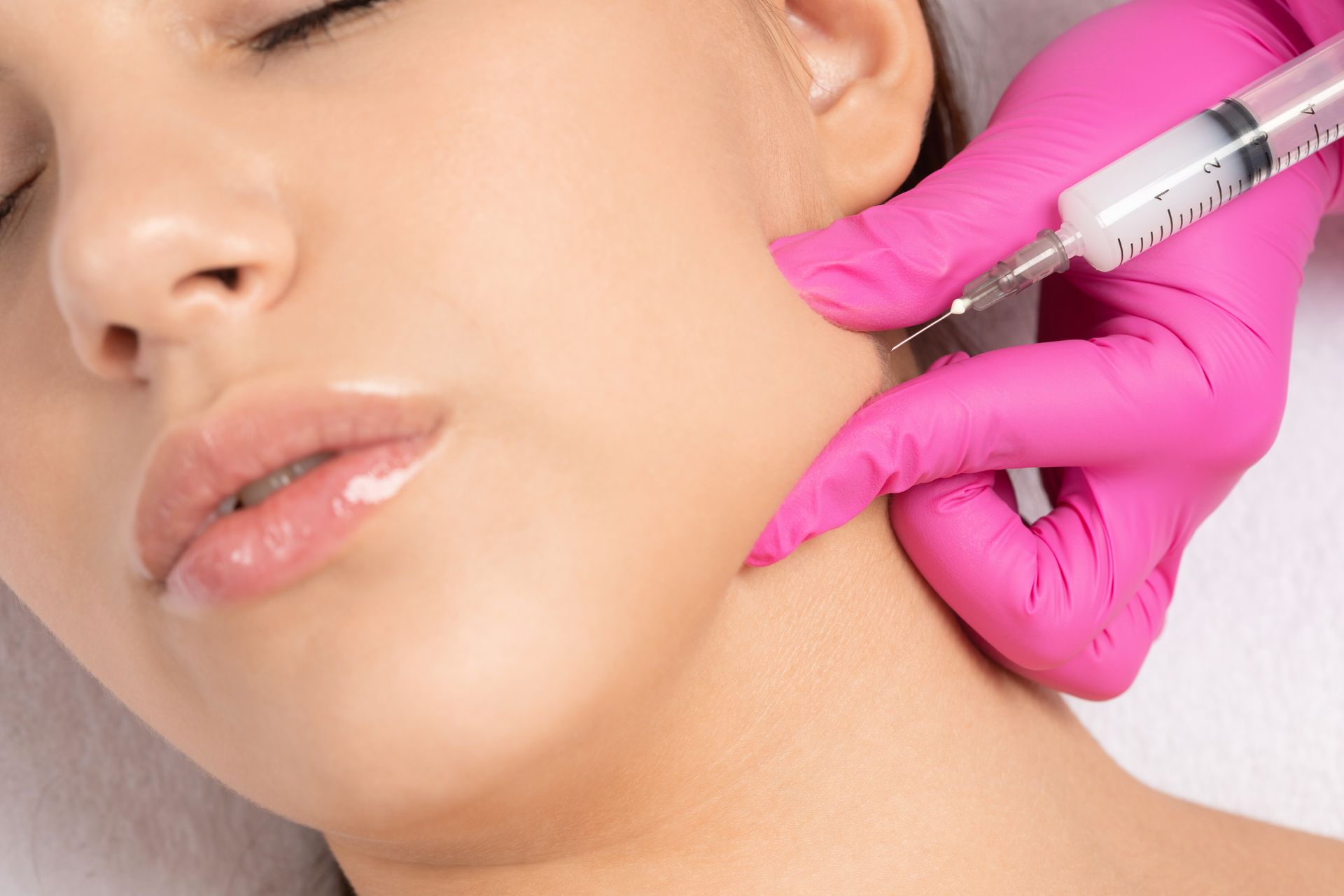 A woman is getting a botox injection in her face.