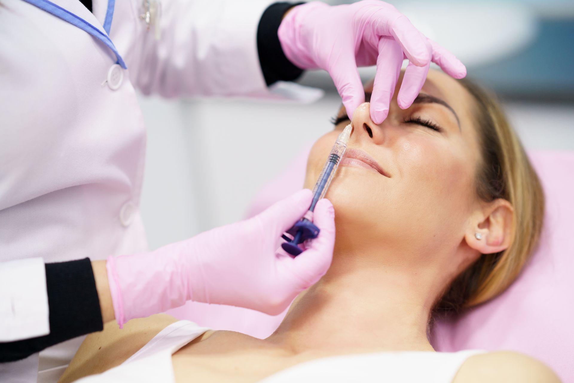 A woman is getting a botox injection in her nose.