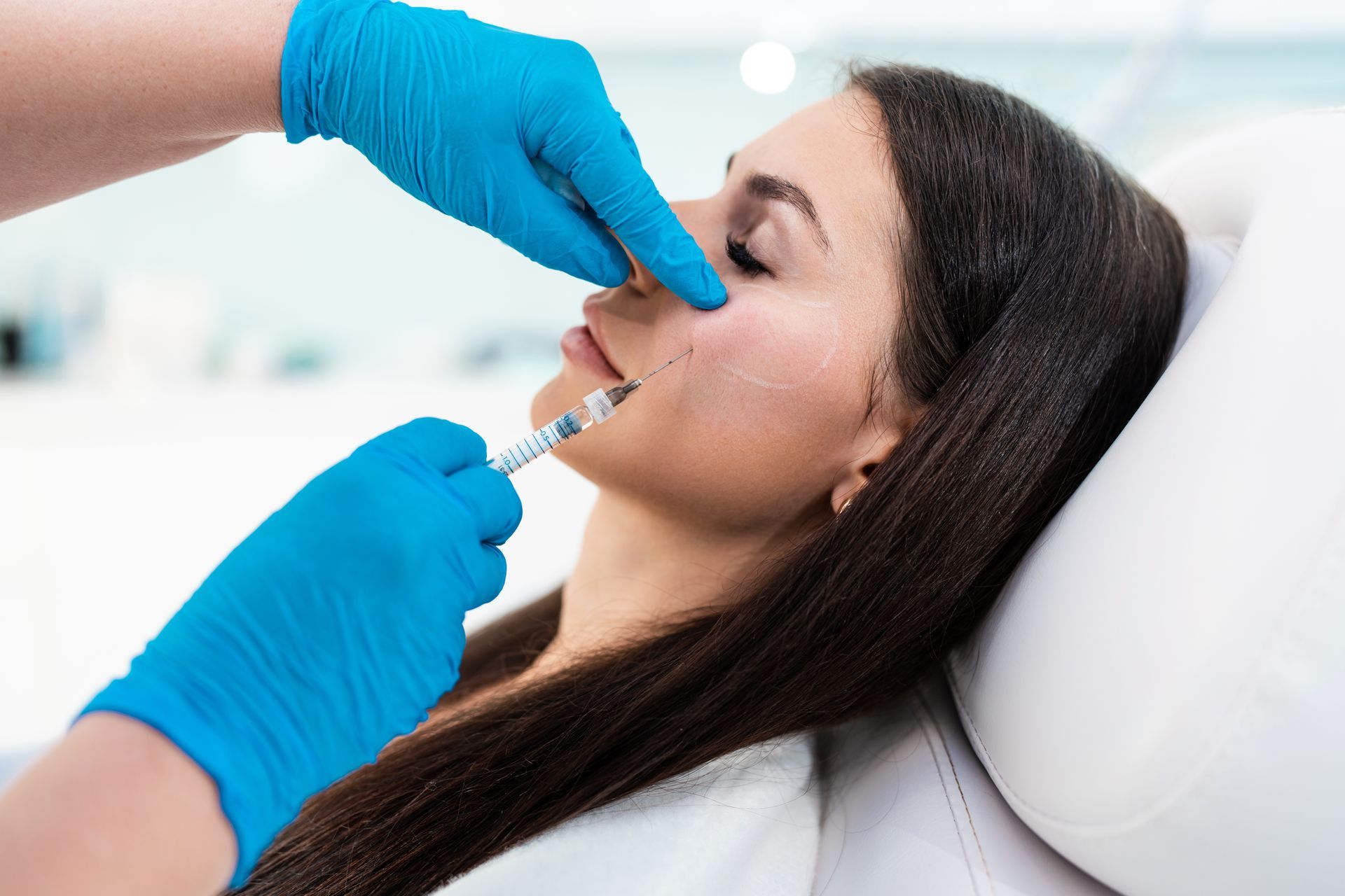 A woman is getting a botox injection in her nose.