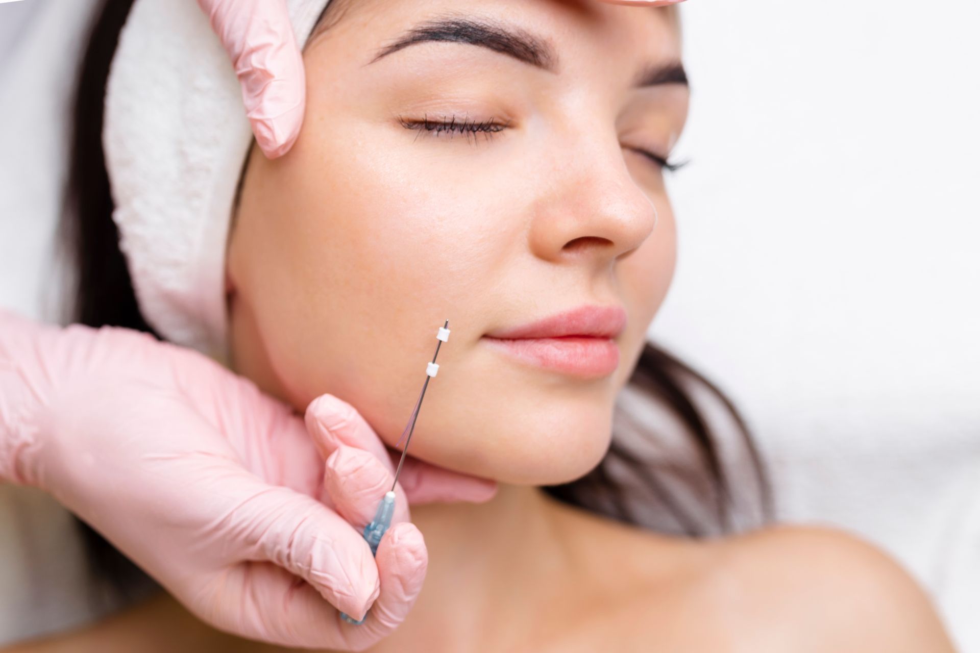 A woman is getting a botox injection in her face.