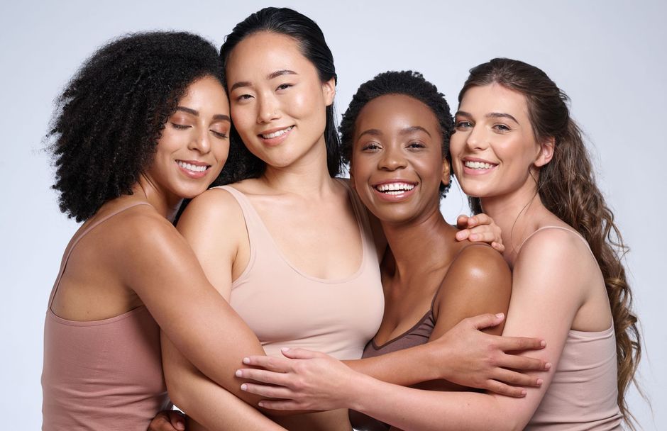 A group of women are hugging each other and smiling.