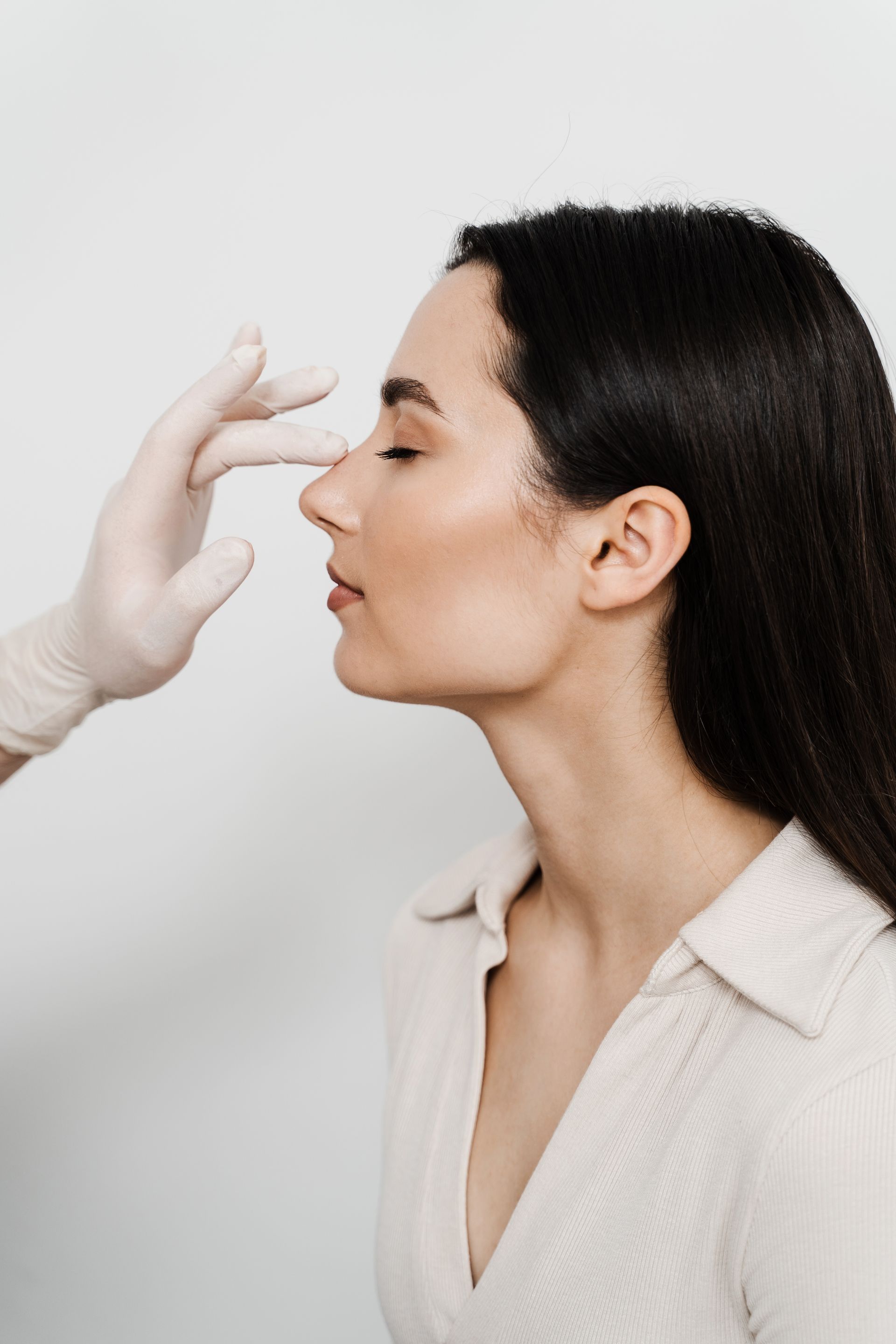 A woman is getting her nose examined by a doctor.