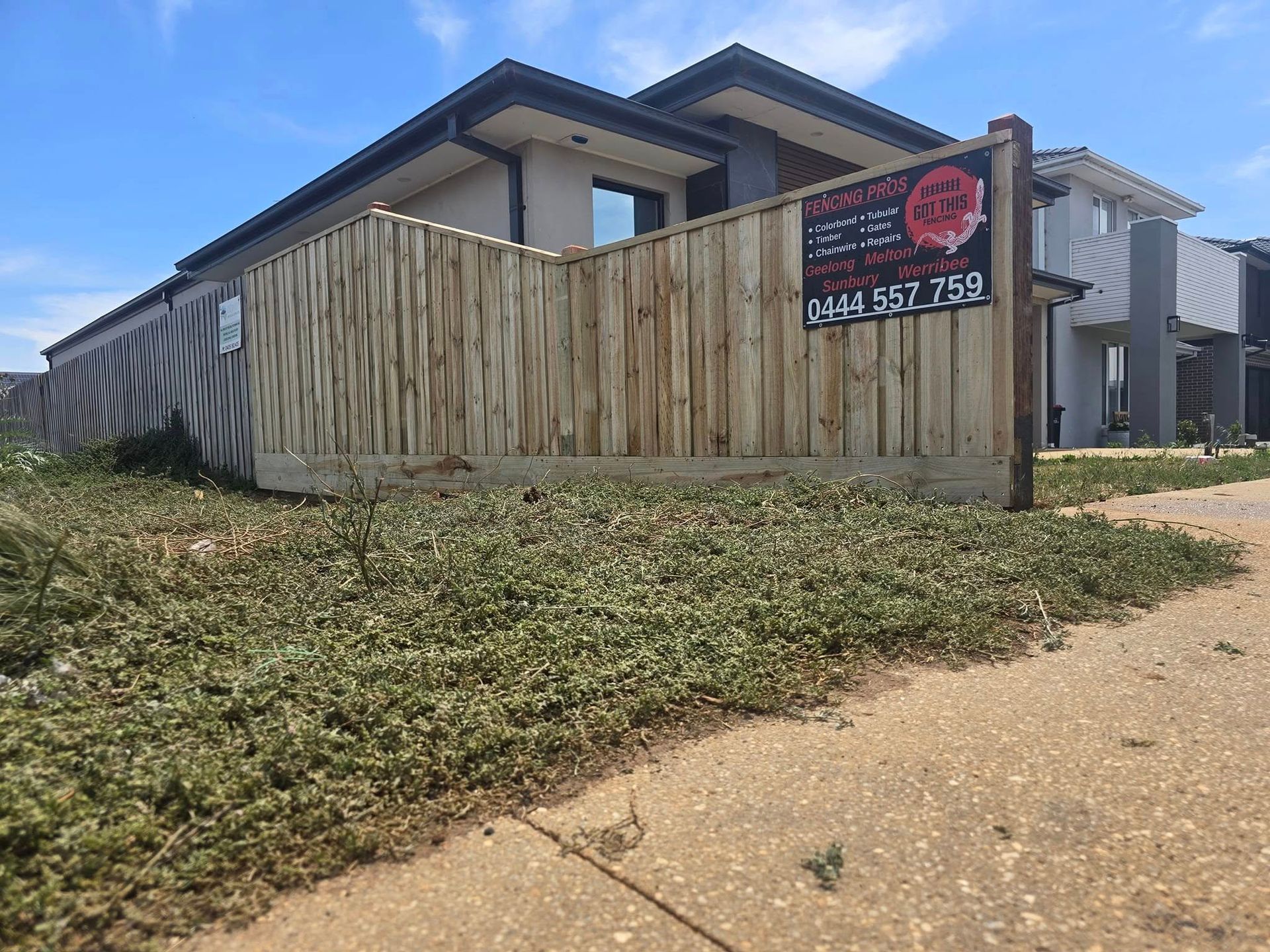 A house for sale with a wooden fence in front of it.