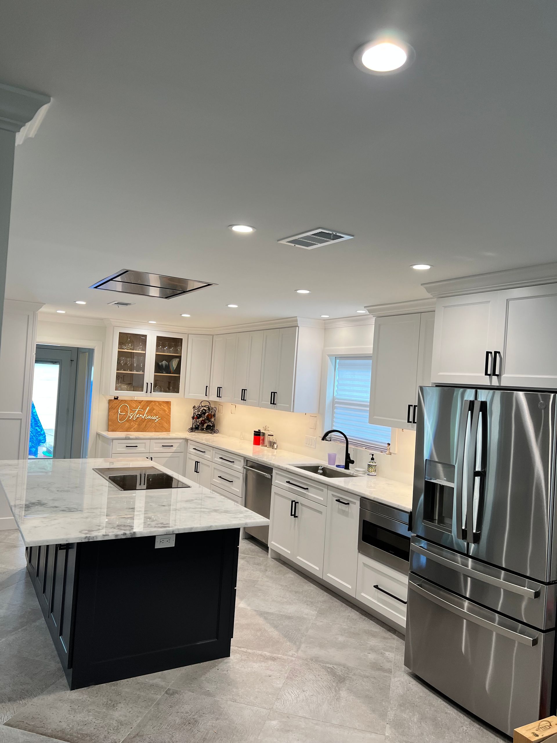 A kitchen with stainless steel appliances and white cabinets.