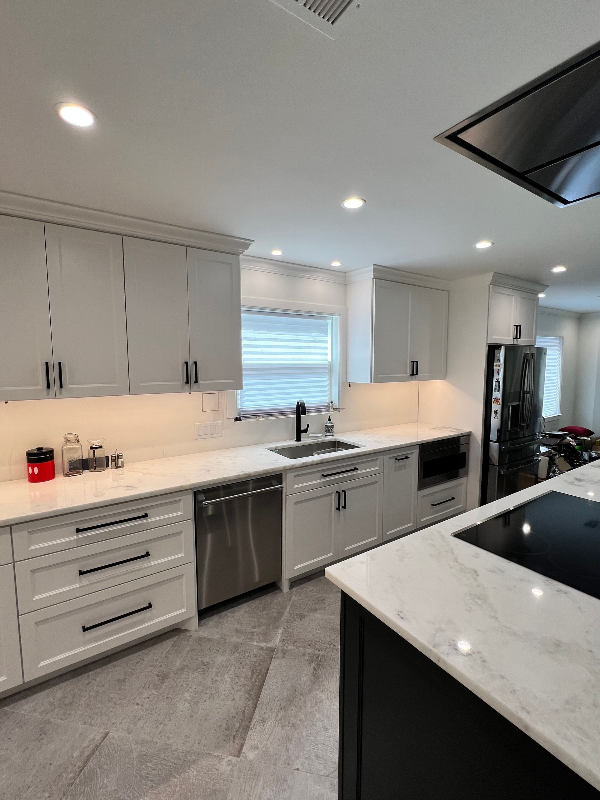A kitchen with white cabinets and stainless steel appliances