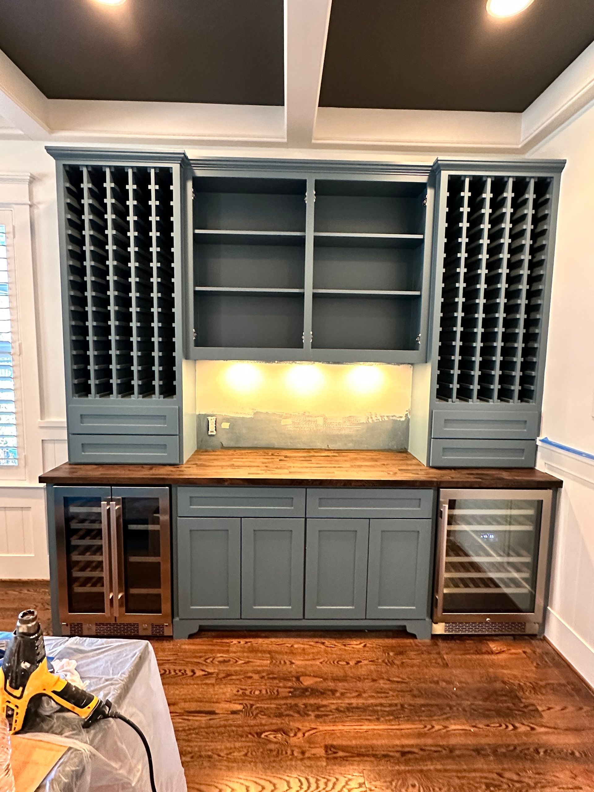 A kitchen with a wine rack and a refrigerator.