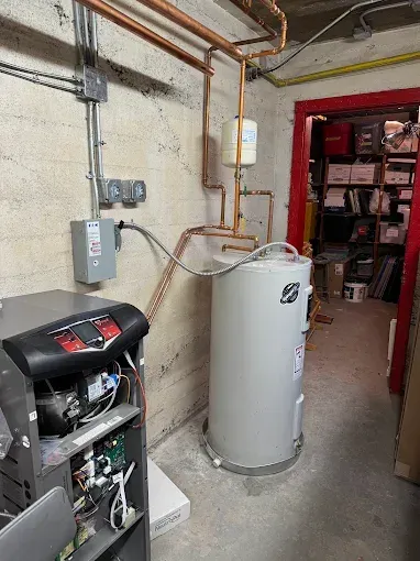 Utility room with water heater, furnace, exposed pipes, and storage shelves in the background
