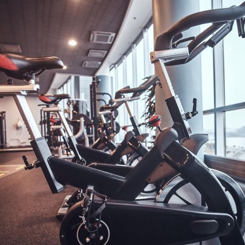 A row of exercise bikes are lined up in a gym.