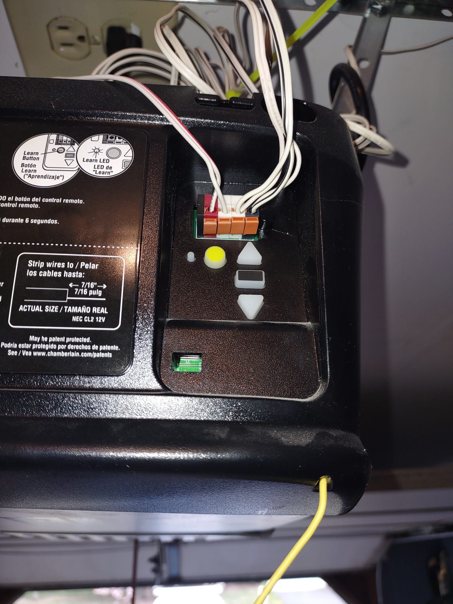 A close up of a garage door opener with wires coming out of it
