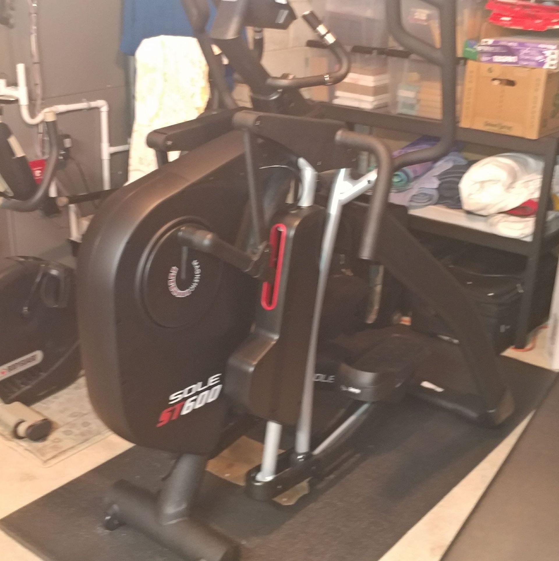 An elliptical is sitting on a mat in a room