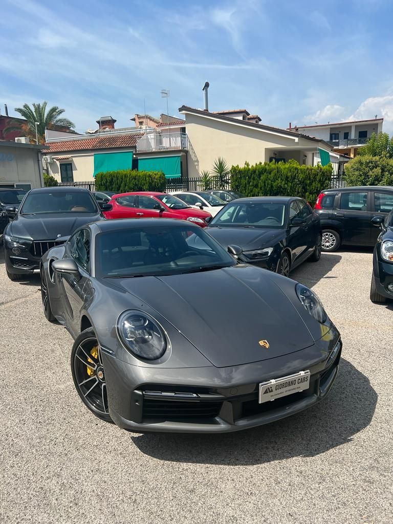 una porsche turbo è parcheggiata accanto a altre auto in un parcheggio