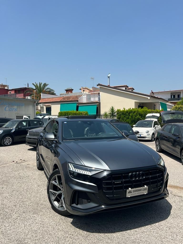 un'audi q8 è parcheggiata in un parcheggio accanto a altre auto