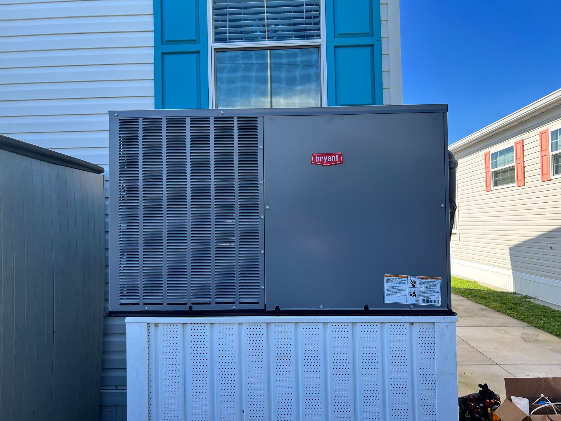 an air conditioner is sitting outside of a mobile home .