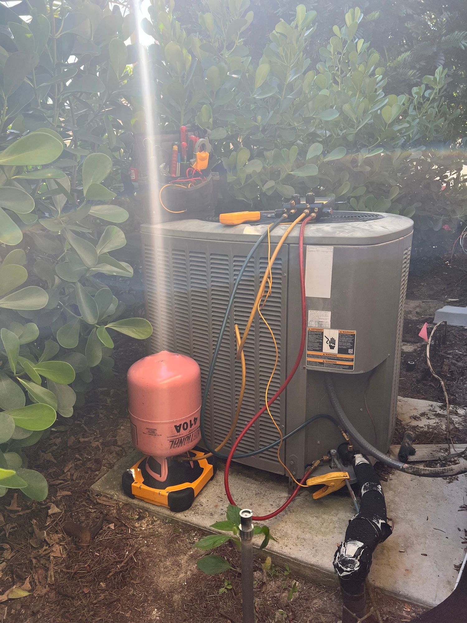 an air conditioner is being installed in a backyard .