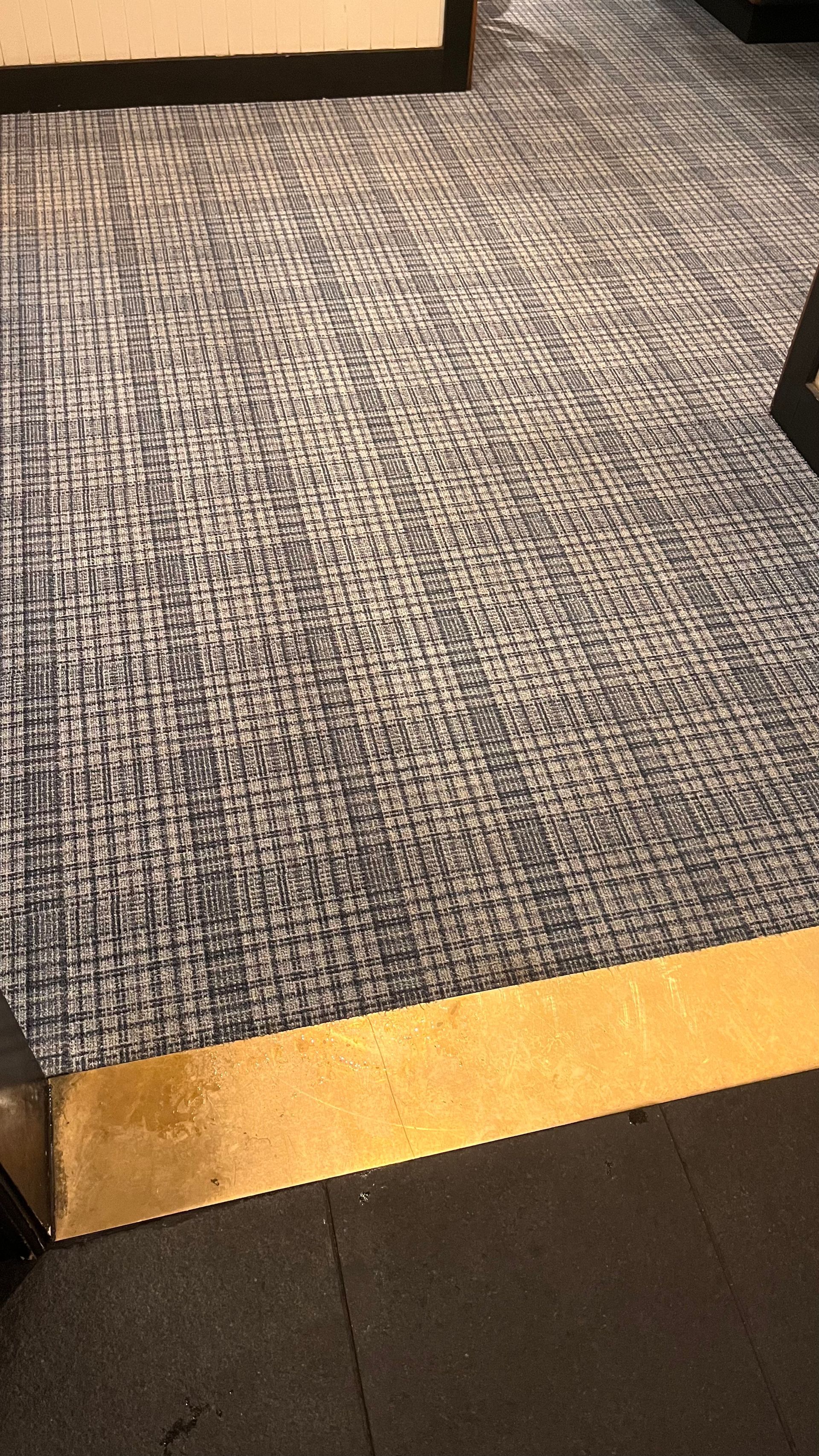 A close up of a carpeted floor with a yellow border.