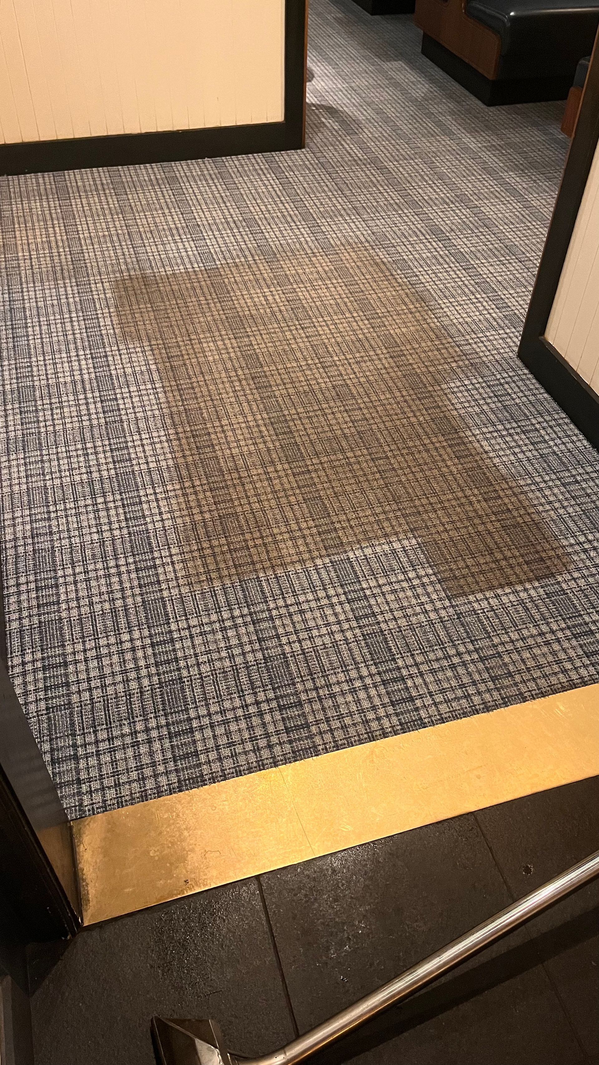 A vacuum cleaner is cleaning a dirty carpet in a room.