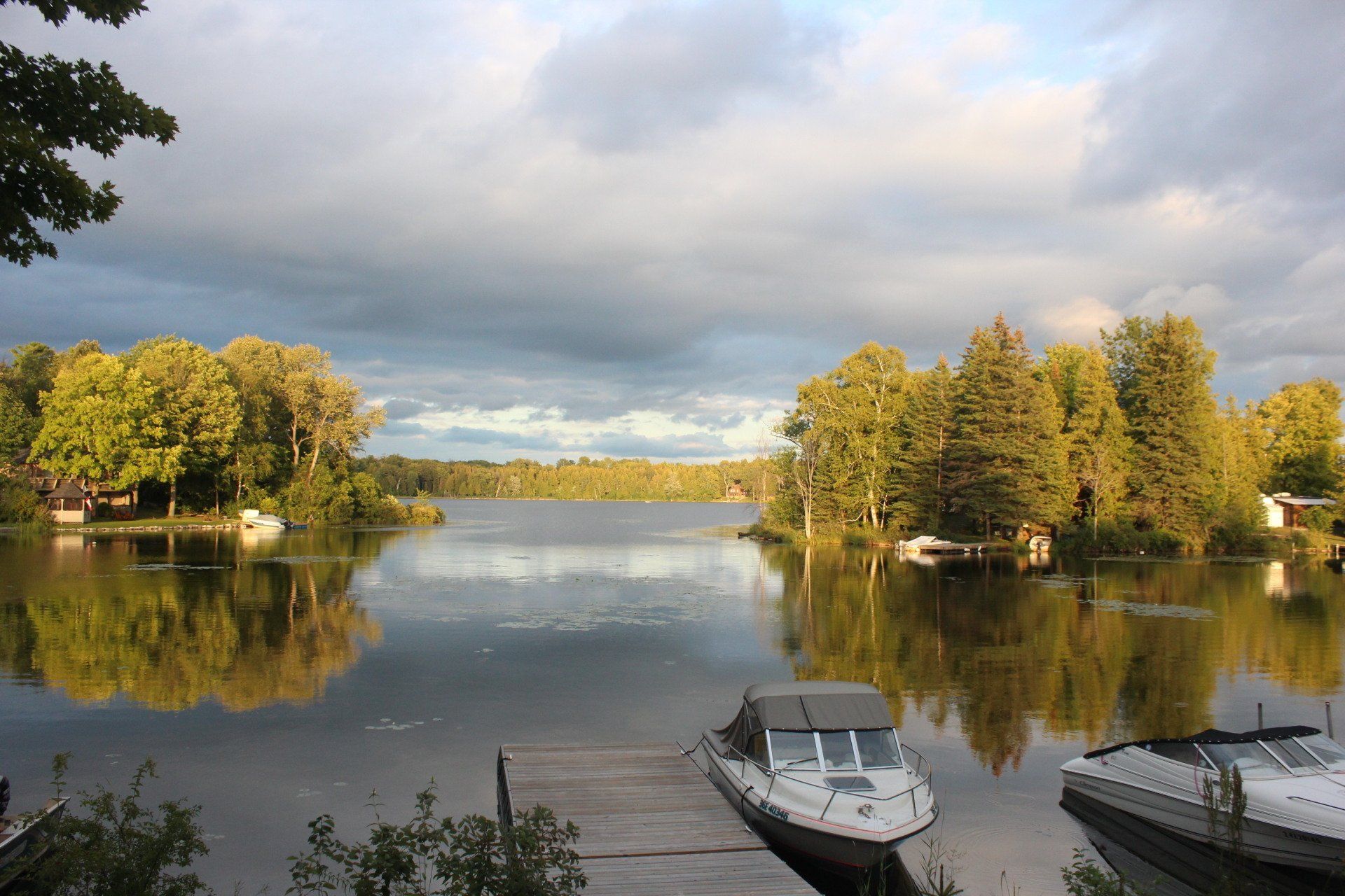 A boat is docked at a dock on a lake surrounded by trees.