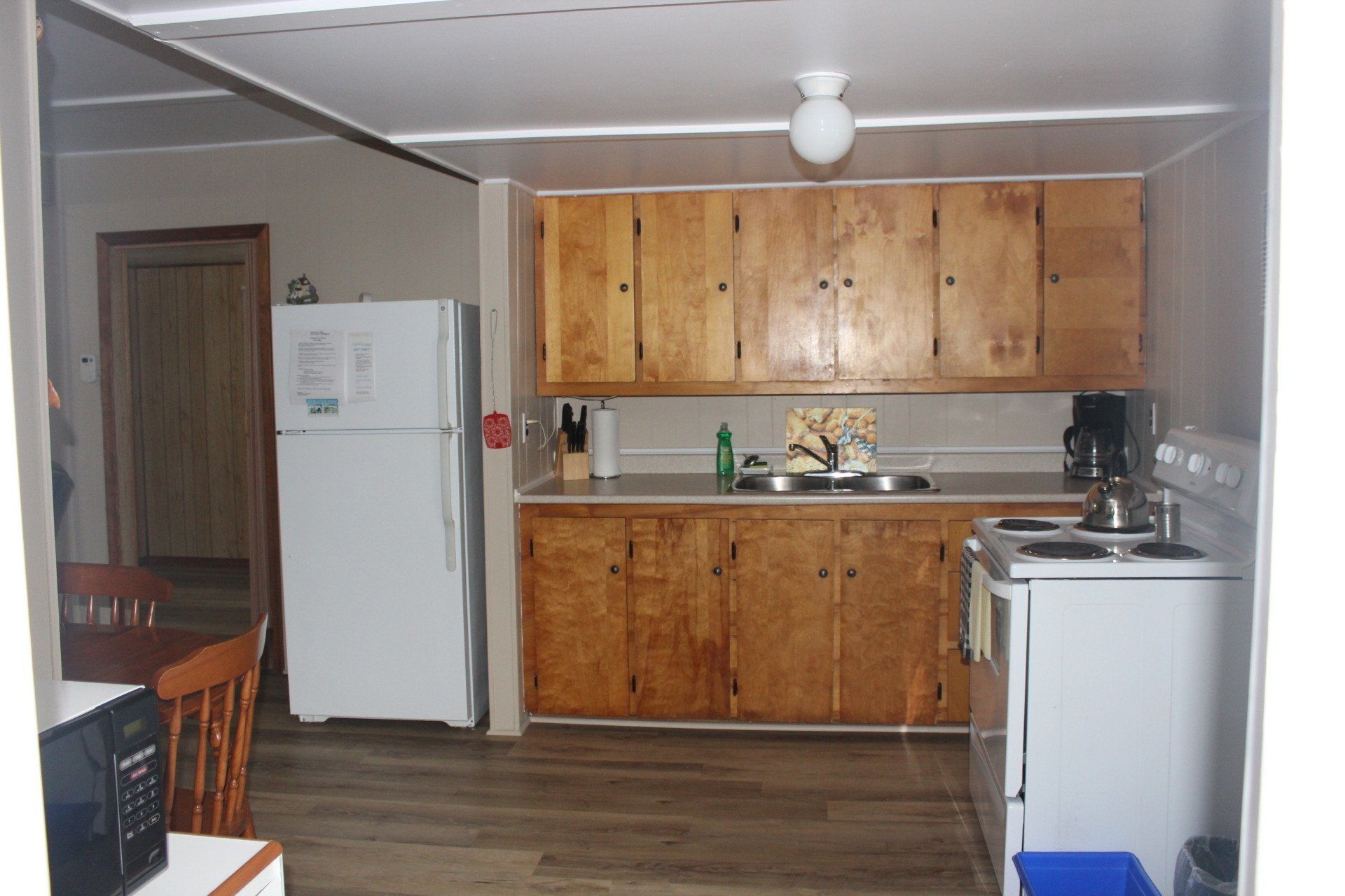 A kitchen with wooden cabinets and a white refrigerator