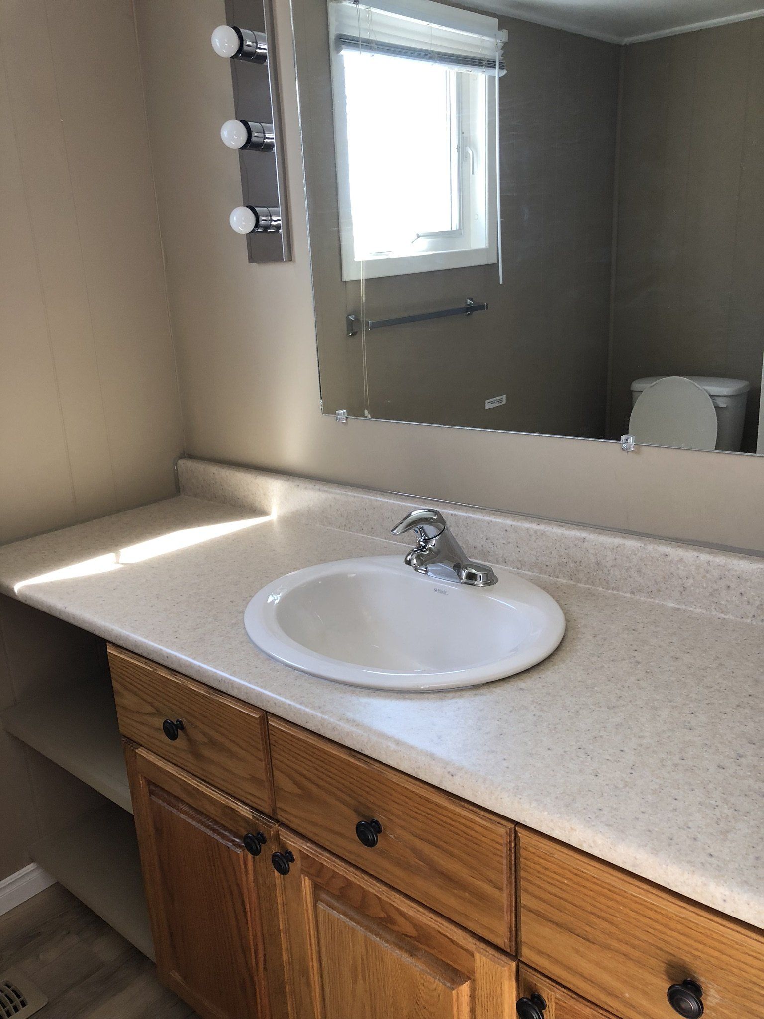 A bathroom with a sink , mirror and toilet.