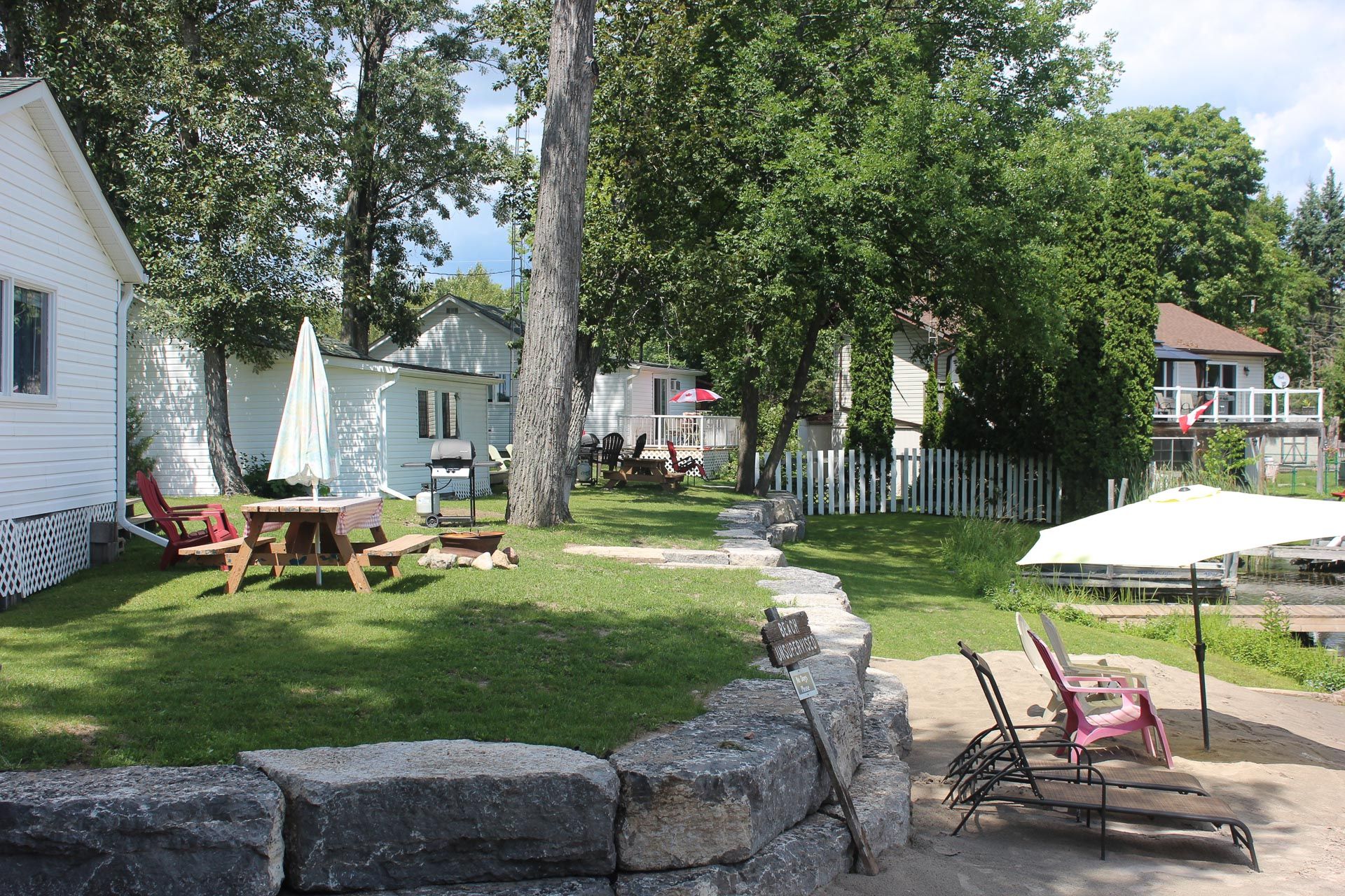 A lawn with a picnic table and chairs in front of a house