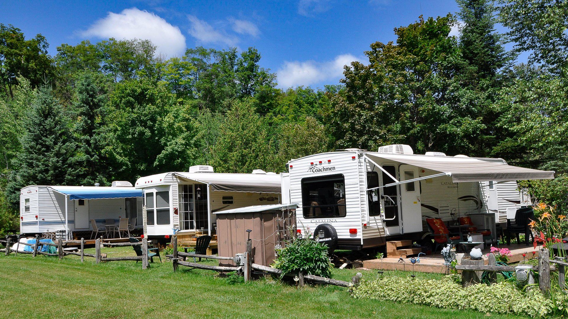 A group of rvs are parked in a grassy field.