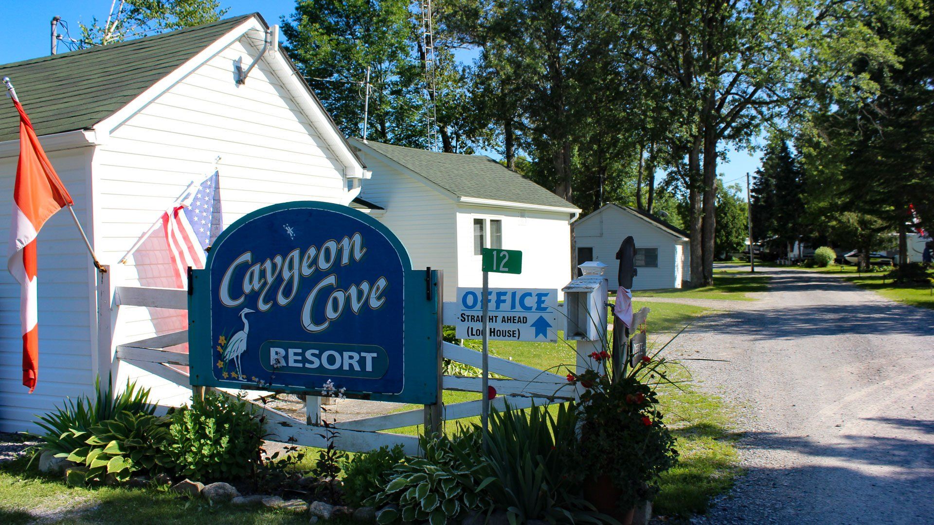 A sign for caryson cove resort is in front of a white building