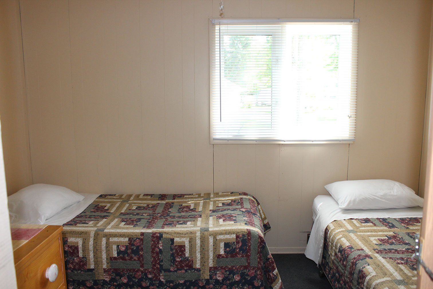 A bedroom with two beds and a window