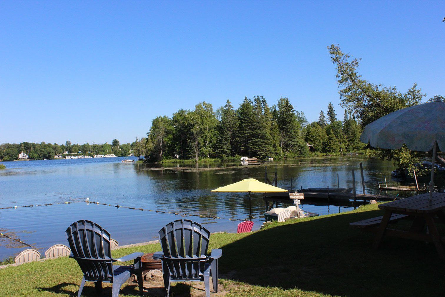 A couple of chairs are sitting in front of a lake.