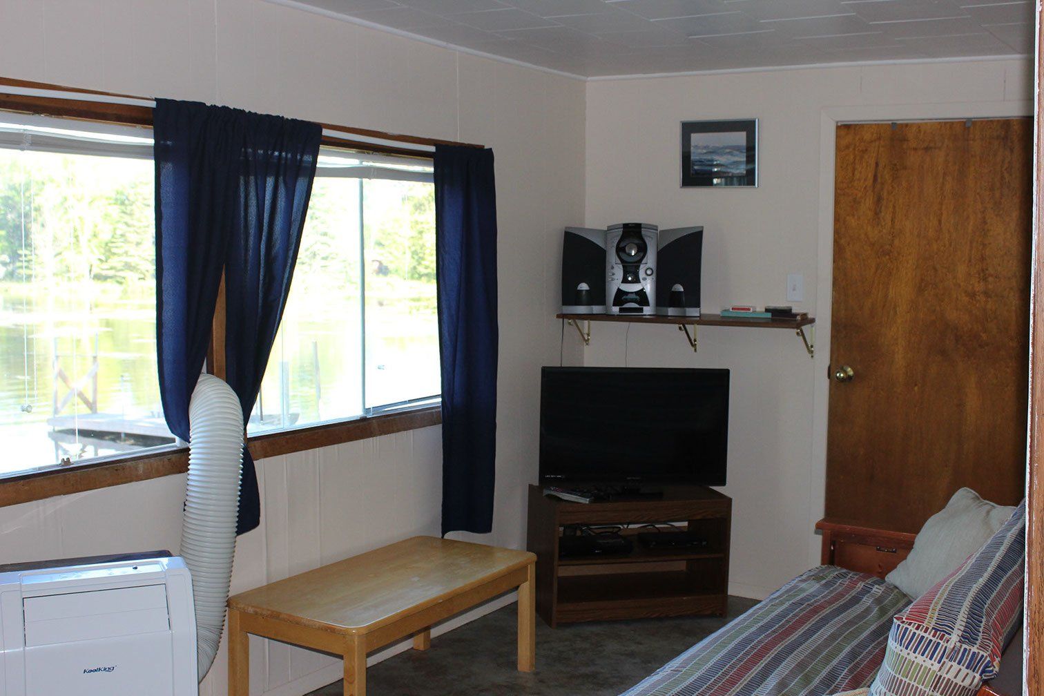 A living room with a couch , table , television and speakers.