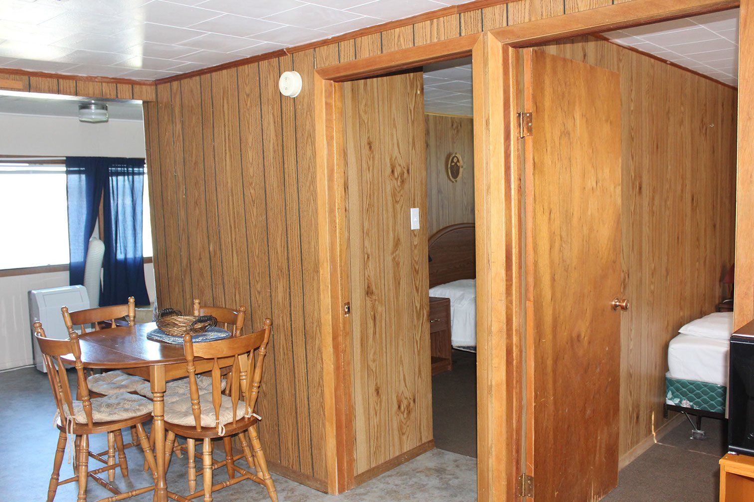 A room with wood paneling and a table and chairs