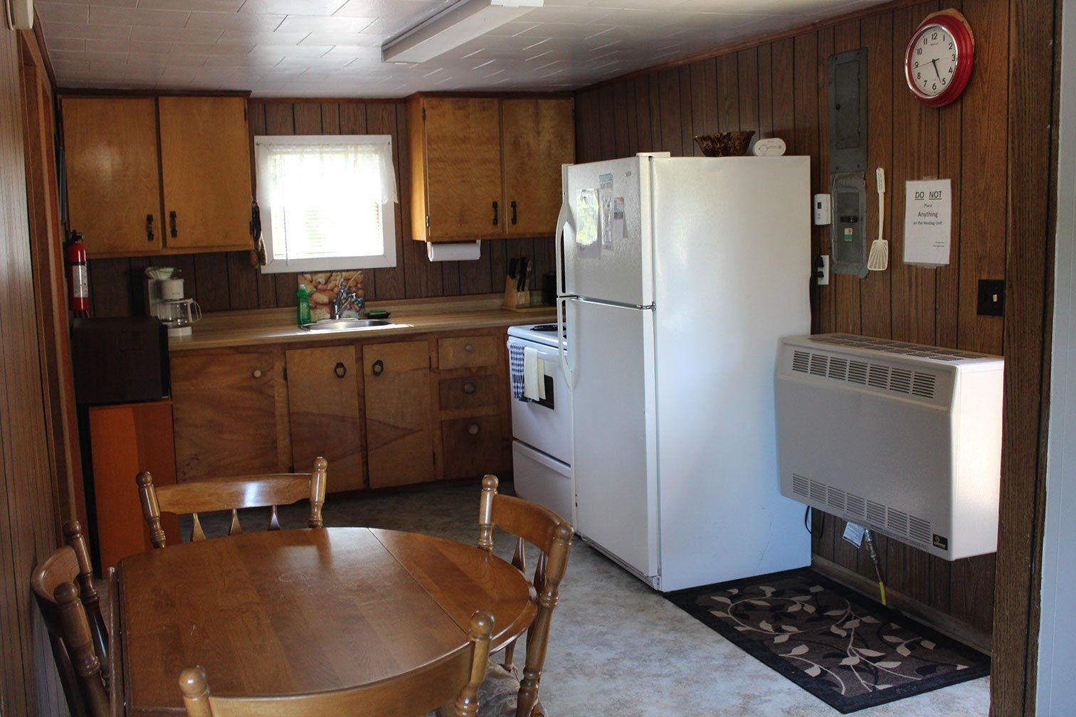 A kitchen with a table and chairs and a refrigerator