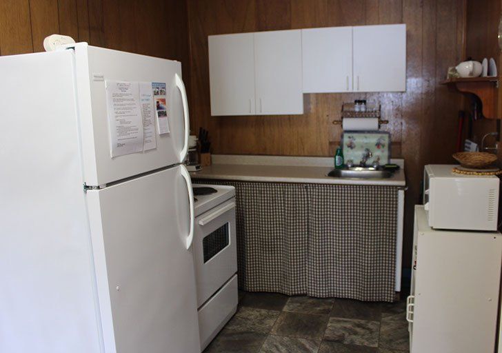 A kitchen with a white refrigerator stove and microwave