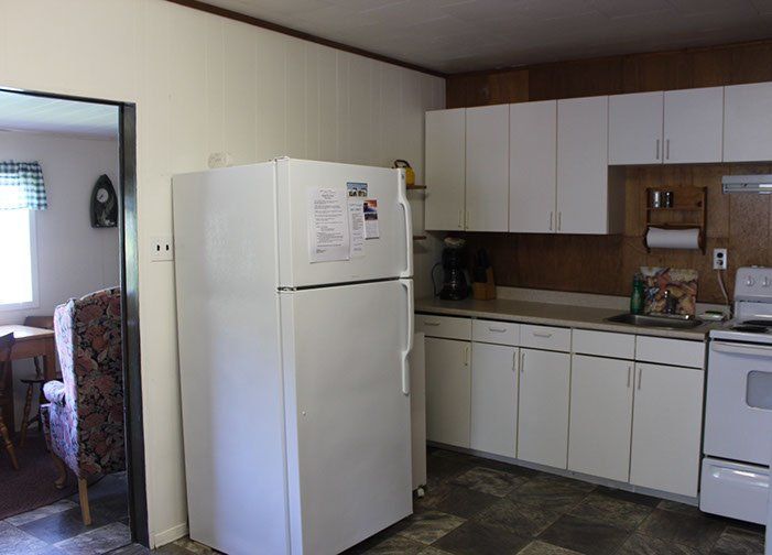 A kitchen with white cabinets and a white refrigerator