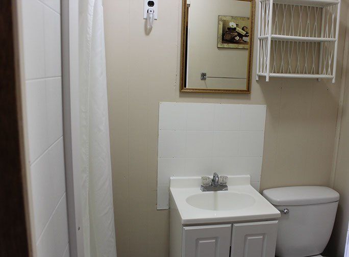 A bathroom with a sink toilet and mirror
