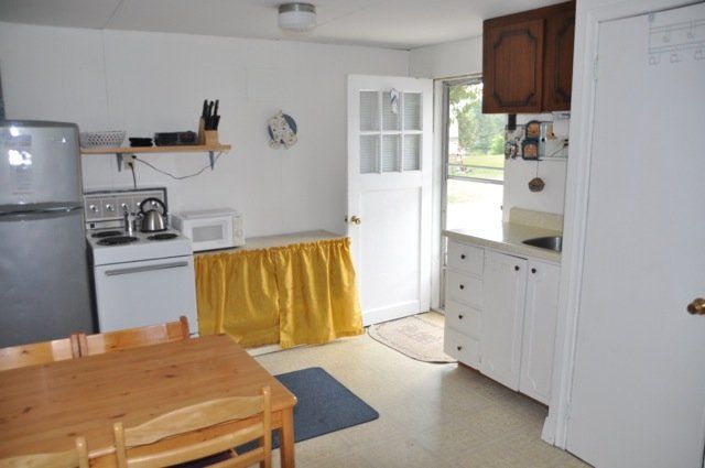 A kitchen with a table and chairs and a refrigerator
